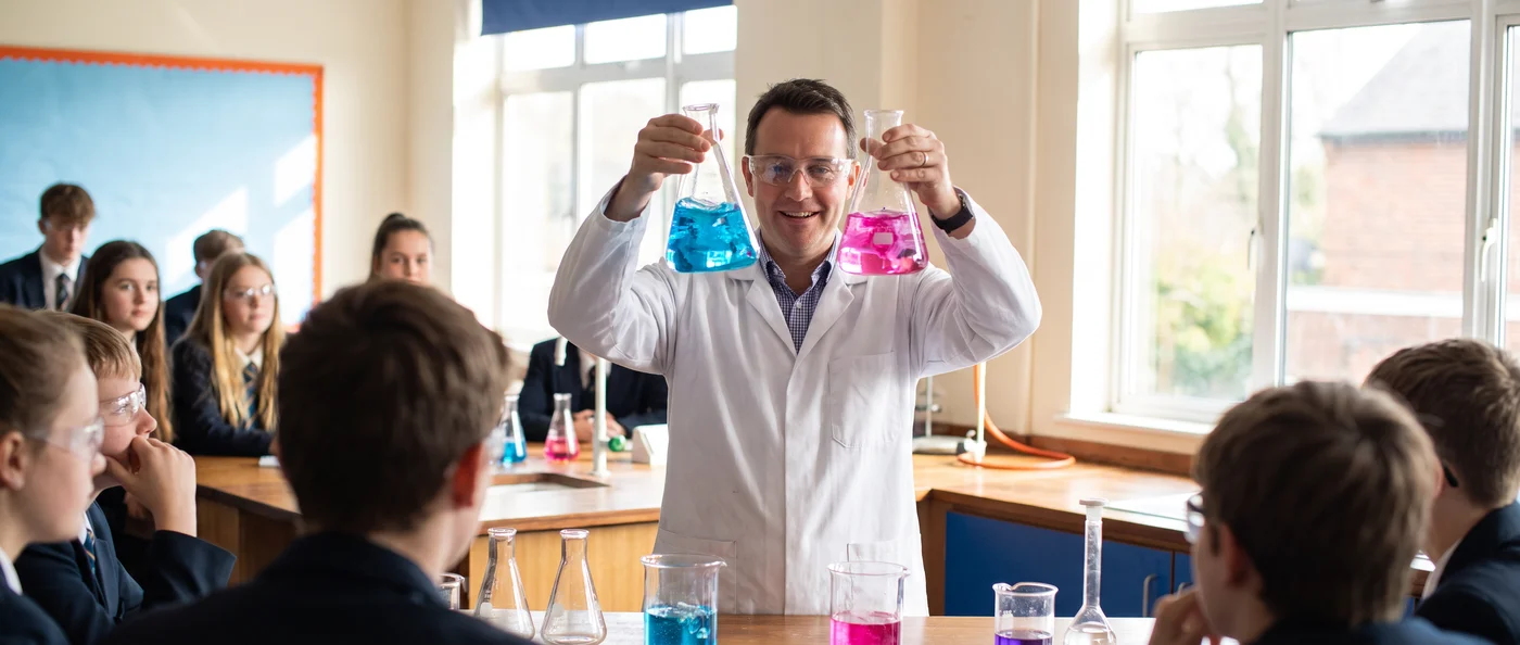 A chemistry teacher demonstrating a colourful reaction to a class